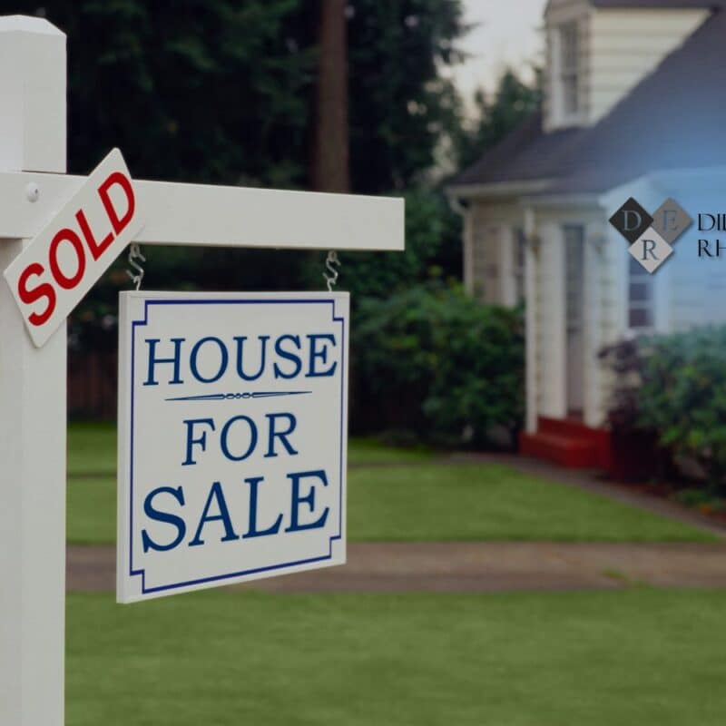 A real estate yard sign with a sold sticker in front of a home, illustrating a legal dispute requiring real estate litigation.
