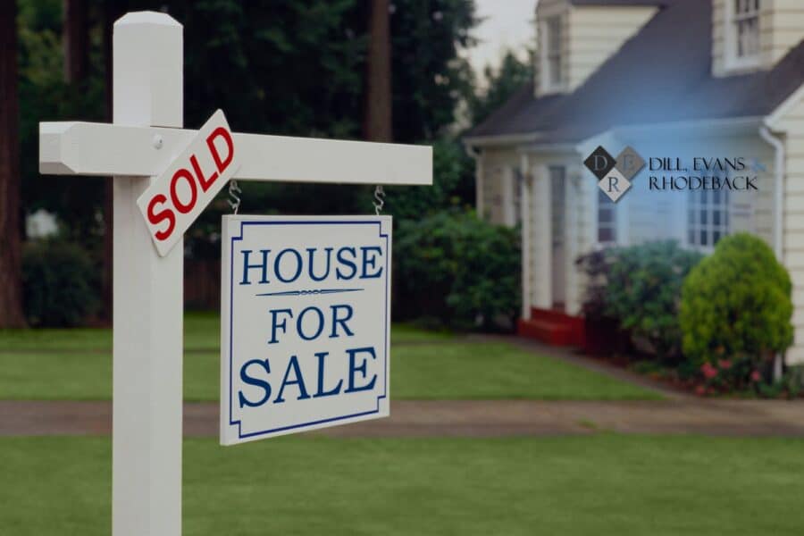 A real estate yard sign with a sold sticker in front of a home, illustrating a legal dispute requiring real estate litigation.