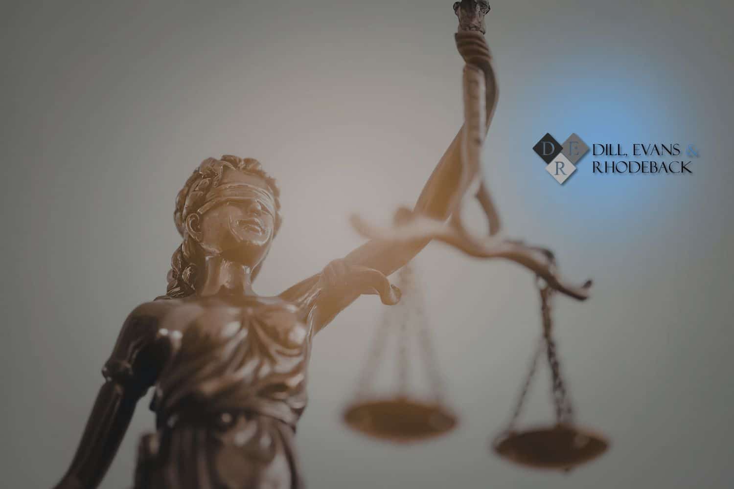 A bronze statue of Lady Justice with scales, representing the different types of litigation handled by a civil law firm.